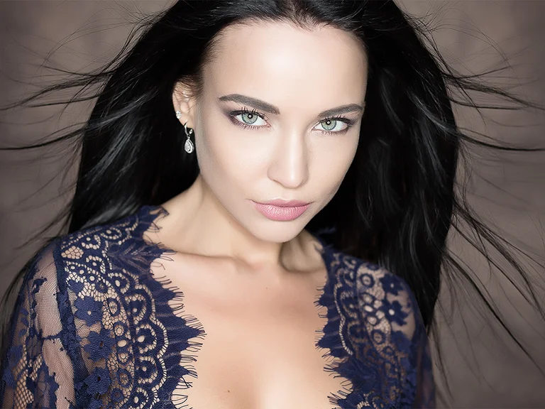 Séance charme : portrait glamour d’une femme brune en dentelle bleu nuit, réalisé en studio à Genève
